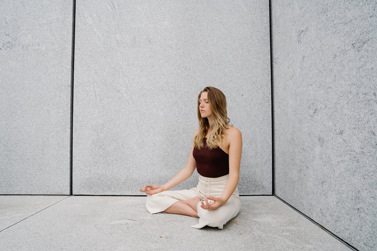 Young woman practicing yoga meditation indoors with calm expression and peaceful atmosphere.